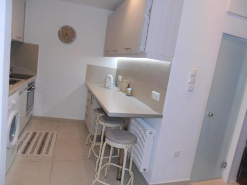 uma cozinha com um balcão, um lavatório e bancos em Velvendou 36A Apartment em Atenas