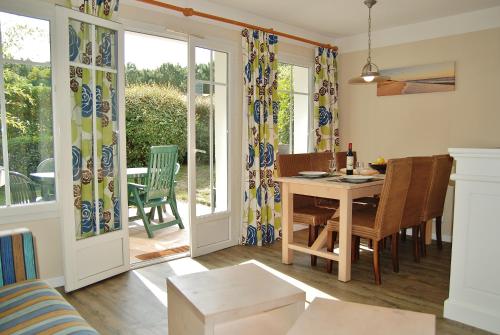 une cuisine et une salle à manger avec une table et des chaises dans l'établissement Charmante maison dans le Golf, idéal pour les familles, à Lacanau