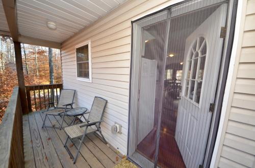 a screened in porch with two chairs and a door at Mt. Maplewood Split Chalet in Pocono Lake