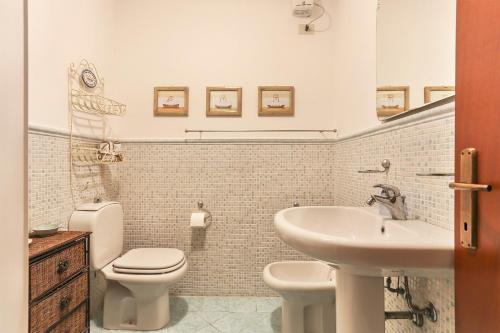 a bathroom with a white toilet and a sink at Soleado beach house in Pietrasanta