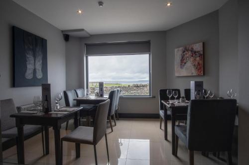 a dining room with tables and chairs and a window at Wilde Ballybunion in Ballybunion