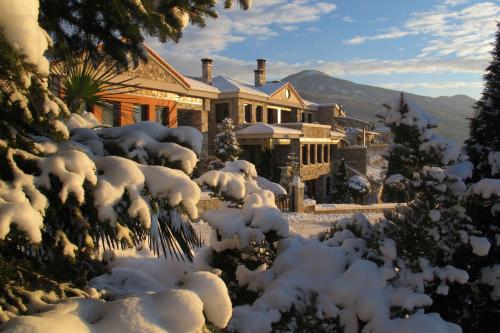 una casa cubierta de nieve en las montañas en Leventis Art Suites, en Panayítsa