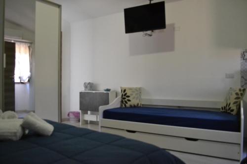 a bedroom with two beds and a tv on the wall at Sa domu rubia in Iglesias