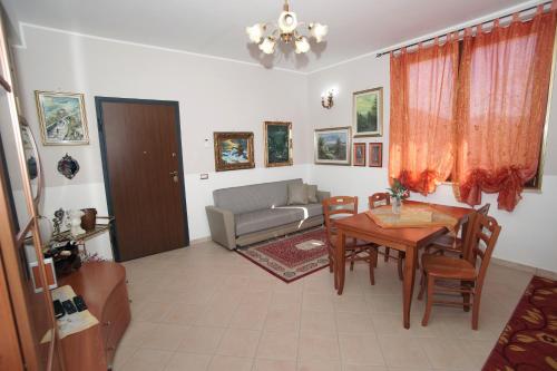 a living room with a table and a couch at Arcobaleno Apartment in Fondi