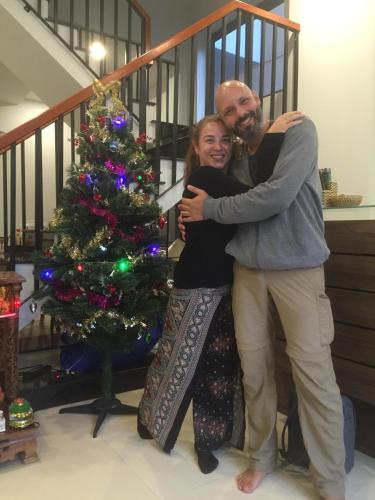 a man and woman hugging next to a christmas tree at candyinn in Hue