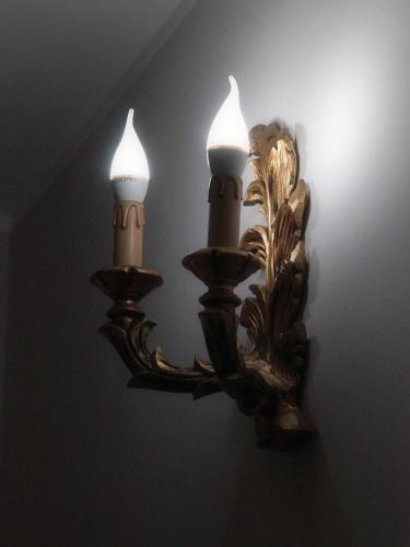 a wall light with two candles and a mirror at Arcobaleno Apartment in Fondi