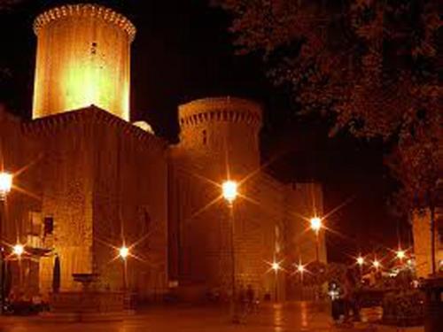 a lit up building with street lights at night at Arcobaleno Apartment in Fondi