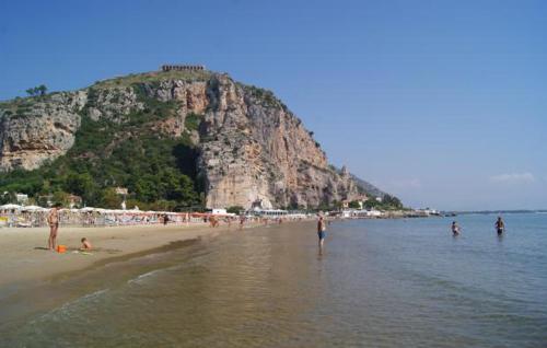 a group of people on a beach with a mountain at Arcobaleno Apartment in Fondi
