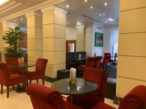a waiting room with tables and red chairs at Hotel dei Mellini in Rome