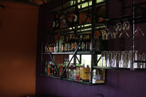 a bar with bottles and glasses on a wall at Governors Club in Entebbe