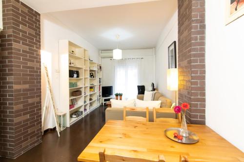un soggiorno con tavolo in legno e muro di mattoni di F & B Collection - Apartment for 3 a Salonicco
