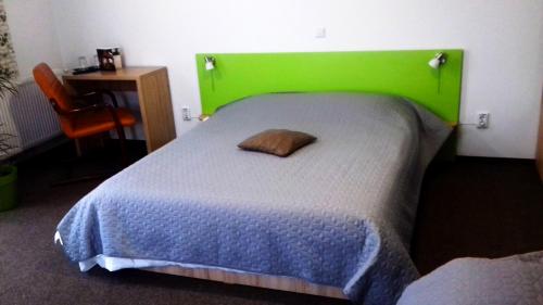 a bed with a green headboard in a room at Vila William’s in Braşov
