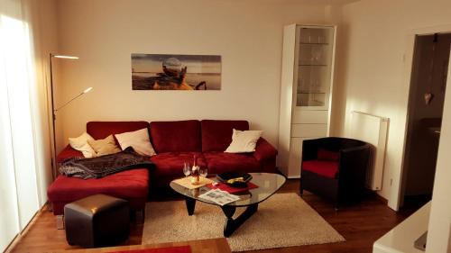a living room with a red couch and a glass table at Pier 605 - 4 Sterne - 300m Strand Zentrum - POWER WLAN - 2 Parkplätze - early CheckIn - #Bestpreisgarantie# in Zingst