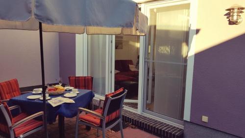 a dining table with chairs and a blue table and a window at Pier 605 - 4 Sterne - 300m Strand Zentrum - POWER WLAN - 2 Parkplätze - early CheckIn - #Bestpreisgarantie# in Zingst