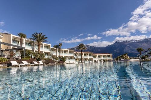 a pool at a resort with mountains in the background at Park Hotel Imperial in Limone sul Garda