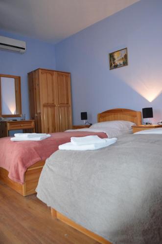 - 2 lits dans une chambre aux murs bleus dans l'établissement Hotel Kramus, à Ruse