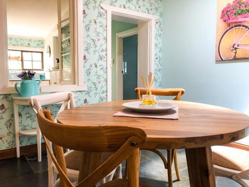 een eetkamer met een houten tafel en stoelen bij Inglenook Cottage in Moonta