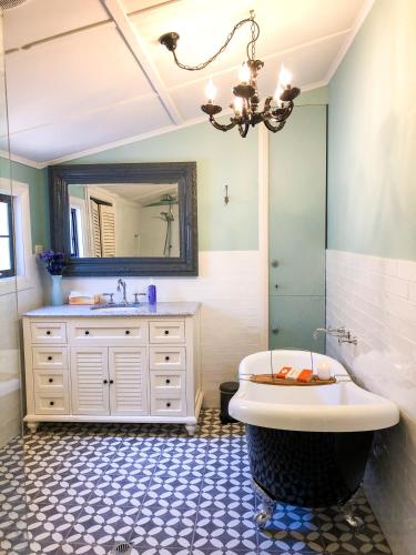 Inglenook Cottage في مونتا: حمام مزود بحوض استحمام ومغسلة ومرآة