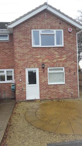 a brick house with a white door and windows at 75ers private room in Cheltenham