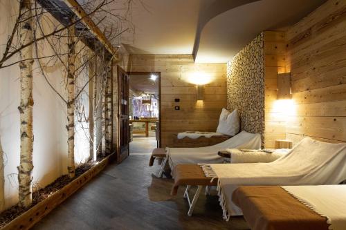 Zimmer mit 2 Betten und Bäumen an der Wand in der Unterkunft Hotel Astoria in Fiera di Primiero