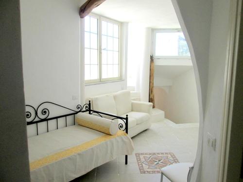 a living room with a white couch and a window at Sardinia Yellow House in Solanas