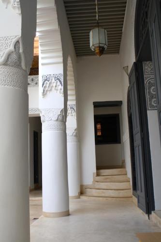 a hallway of a building with columns and a door at Riad Yamcha in Meknès