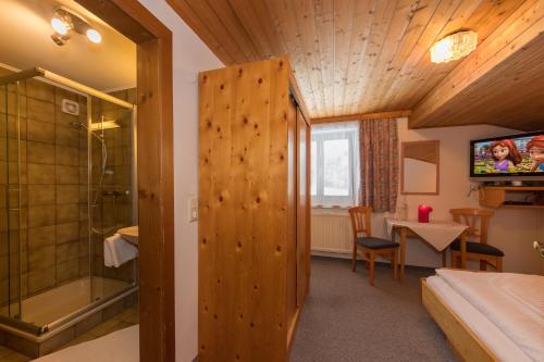 a room with a bed and a shower and a television at Teufenbachgut in Lend