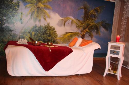 a bed with a red blanket and a candle on it at Erwachsenen Aparthotel Naturidyll - Der Wieserhof in Bad Füssing