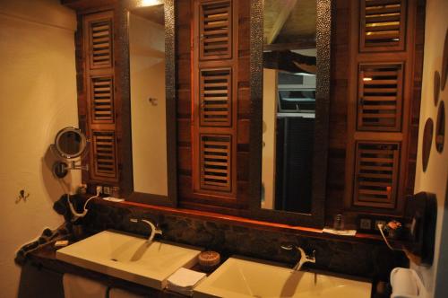 a bathroom with two sinks and a large mirror at Mango Island Lodges in Saint Joseph