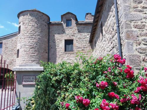 a stone building with pink flowers in front of it at Gîte de Rouviac in Castelnau-Pégayrols