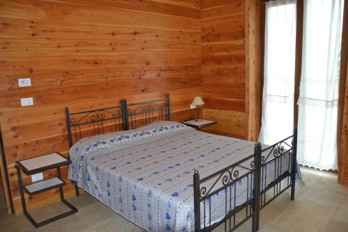 1 dormitorio con 1 cama en una cabaña de madera en Appartamento L'albero e le stelle, en Borgo San Dalmazzo