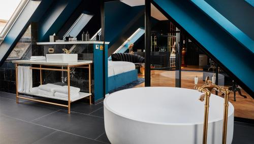 W pokoju znajduje się łazienka z wanną. w obiekcie Provocateur Berlin, a Member of Design Hotels w Berlinie
