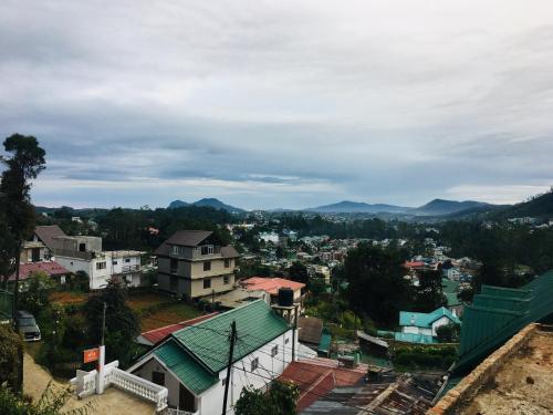 a view of a city with mountains in the background at Golden King Guest in Nuwara Eliya