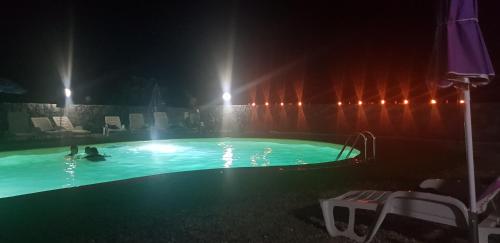 a pool at night with people swimming in it at Il Rustico in Pozzillo