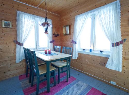 a dining room with a table and chairs in a cabin at Beach View Lofoten in Bøstad