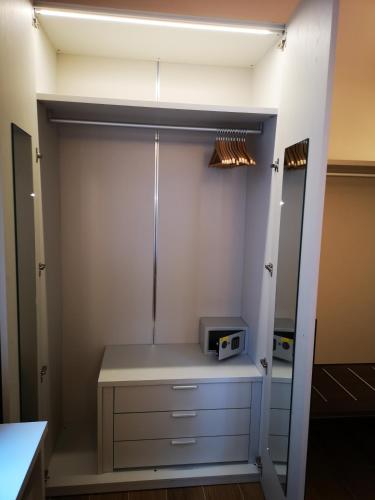 a walk in closet with a microwave and a mirror at 2 Navigli in Milan
