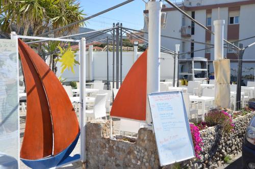 two umbrellas and a sign in front of some tables at Hotel Piccolo Paradiso in Bordighera