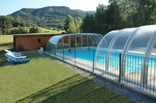 uma casa com piscina ao lado de um edifício em Le Relais de la Forge em Selonnet