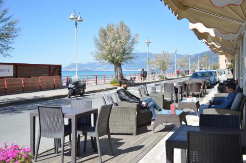 a group of people sitting at tables and chairs at Hotel Piccolo Paradiso in Bordighera