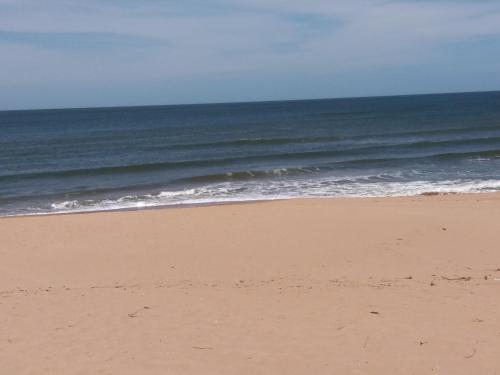 an empty beach with the ocean in the background at Aroma de mar casas en alquiler vacacional con hermosa piscina in Sauce de Portezuelo