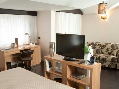Televízia a/alebo spoločenská miestnosť v ubytovaní Hotel Bruman
