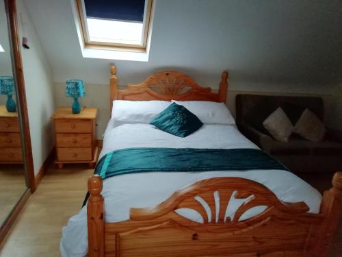 sypialnia z drewnianym łóżkiem i kanapą w obiekcie Joe and Aggies w mieście Kilclooney