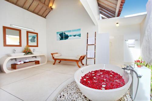 a bathroom with a large tub filled with red flowers at Villa Nico - Private Pool with Onsite Spa in Canggu