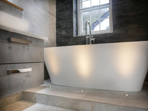 a bathroom with a white sink and a window at Padstow Escapes - The Long Room Luxury Apartment in Padstow
