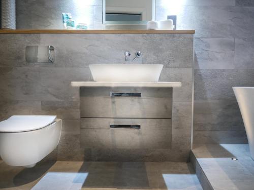 a bathroom with a sink and a toilet at Padstow Escapes - The Long Room Luxury Apartment in Padstow