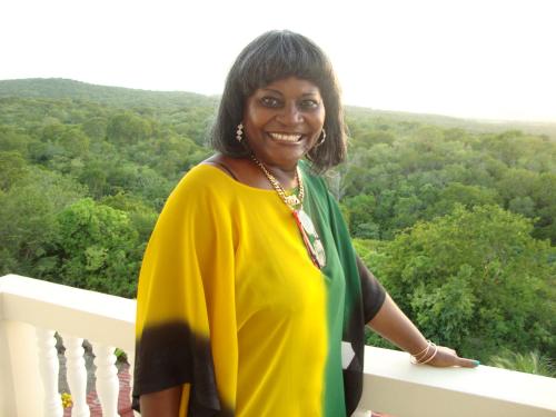 a woman is standing on a balcony at Retreat Guest House in Falmouth