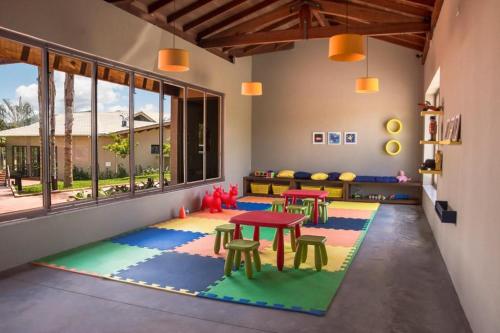 a room with tables and chairs on a rug at Pousada Terramare in Guapé