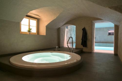 a large bathroom with a large bath tub with a window at Botique & SPA Hotel Berkenes Manor in Ziedkalne