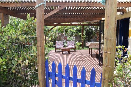 a wooden pergola with a bench and a table at Complejo Sol de Valizas in Barra de Valizas