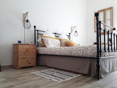 ein Schlafzimmer mit einem Bett mit Kissen und einer Kommode in der Unterkunft Asfodelo in Ragusa
